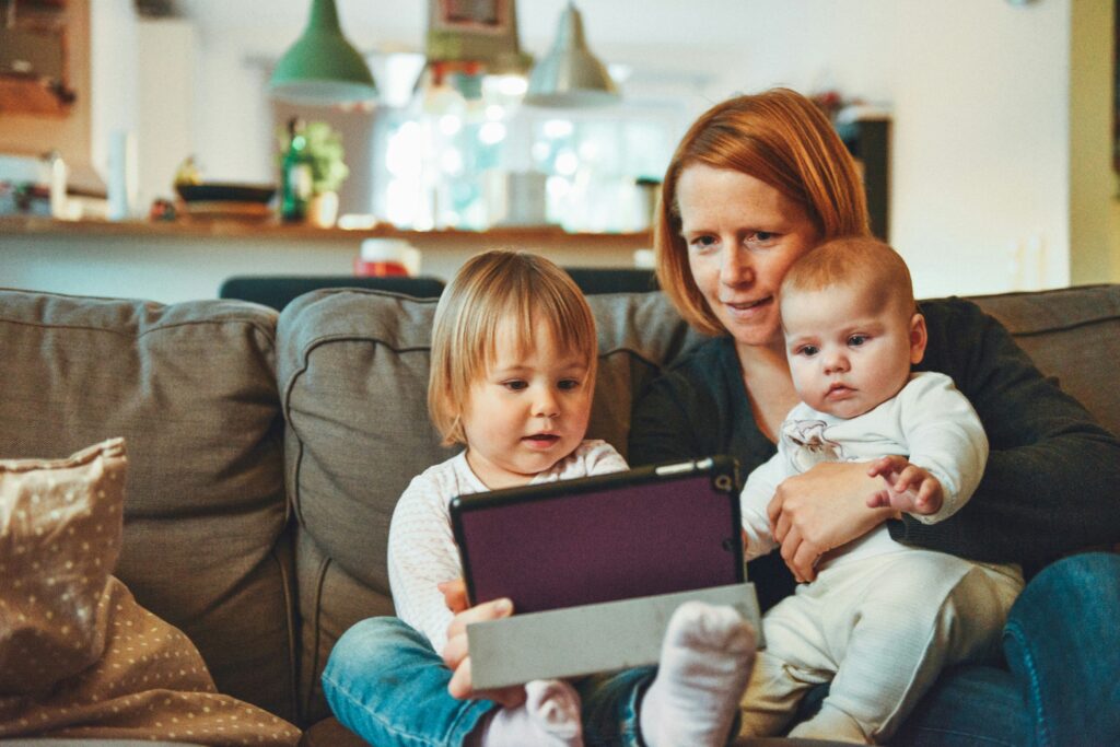 Woman with two babies on couch