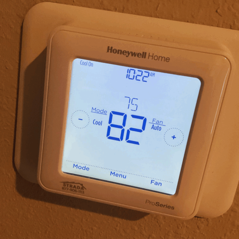 Close-up of a Honeywell Home digital thermostat displaying 82°F, set to cool mode with a target of 75°F.